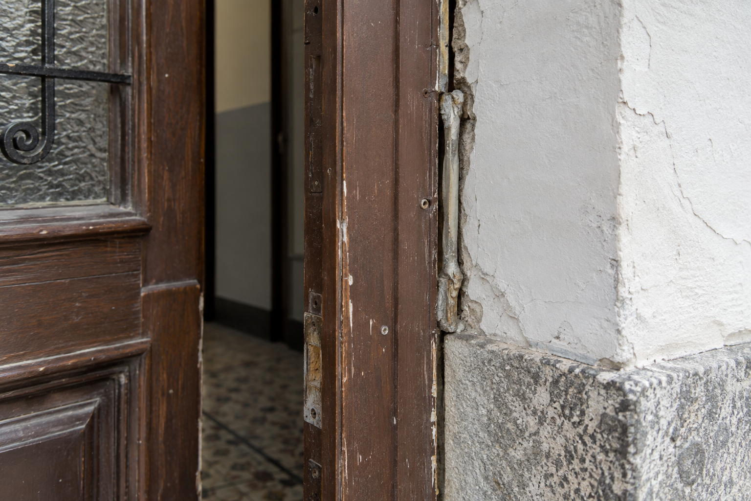 Beschädigte Haustürzarge mit lockerem Rahmen, Anschlussfuge und Mauerwerk